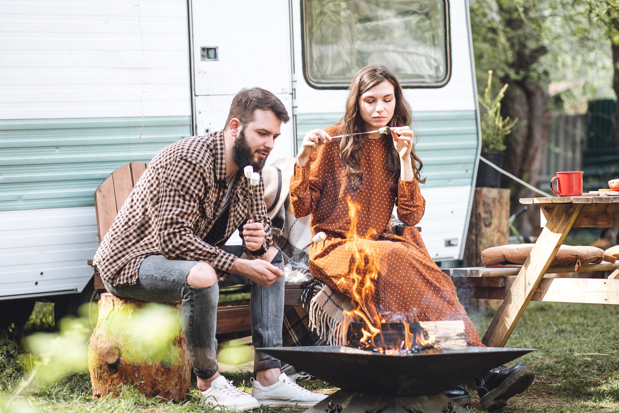 Young couple of newlyweds spending honeymoon or summer vacations travelling in a camper van